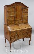 An 18th century German walnut bureau cabinet, with central cupboard flanked by nine drawers over