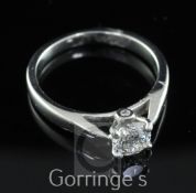 A platinum and single stone diamond ring, with two small diamonds in the setting below, the