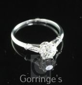 A white gold and single stone diamond ring, with diamond set shoulders, the central old cut stone