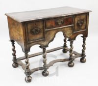 An early 18th century walnut side table, with crossbanded top, three drawers and barley twist legs