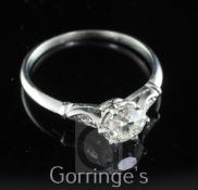 A white gold and single stone diamond ring, with diamond set shoulders, the central round old cut