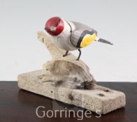§ Guy Taplin (1939-)painted wood,Goldfinch perched on a stump,signed and dated 2000,height 5.5in.