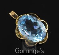 An 18ct gold and solitaire blue topaz pendant, with claw set oval fancy facet cut stone, overall 1.