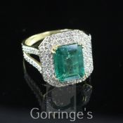 An 18ct gold, emerald and diamond cluster dress ring by Lorique, of octagonal form, the central