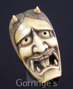 A Japanese Oni mask Manju netsuke, 19th century, with open mouth, engraved two character