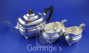 A George VI silver three piece tea set by William Hutton & Sons Ltd, of oval form, on ball feet,