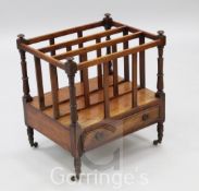 A George III mahogany canterbury, with triple slatted divisions and base drawer, on ring turned legs