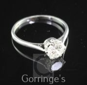 A platinum and solitaire diamond ring, the round brilliant cut stone weighing approximately 0.75-0.