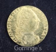 A George III gold guinea, 1777, Fourth head, good VF