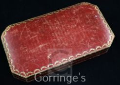 An Edwardian Cartier gilt tooled red leather jewellery box, of rectangular form with canted corners,