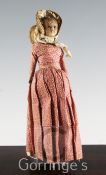 An early 19th century poured wax head and shoulder doll, with kid and fabric body, glass inset eyes,