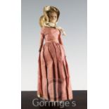 An early 19th century poured wax head and shoulder doll, with kid and fabric body, glass inset eyes,