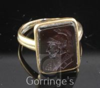 An antique gold and carnelian intaglio ring, of rectangular form, carved with the bust of a Roman