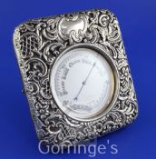 An early 20th century chrome cased travelling barometer in an unmarked repousse silver mounted