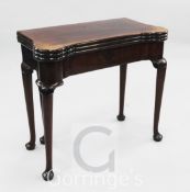 A George II mahogany combined tea, card and games table, with eared triple folding top opening to