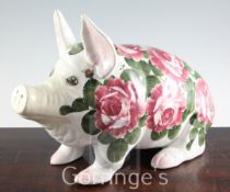 A large Wemyss cabbage rose pattern model of a seated pig, inscribed in green enamel Wemyss,