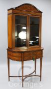 A late Victorian Sheraton revival marquetry inlaid satinwood bookcase, the arched cornice inlaid