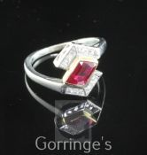 A stylish 18ct gold and platinum, ruby and diamond ring, the central 1.03ct ruby flanked by twelve
