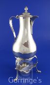 A George III silver hot water jug on tripod stand with burner, of baluster form, with engraved