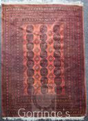 An Afghan Bokhara carpet, with field of twenty four polygons on a burnt orange ground, with