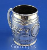 A Victorian silver barrel shaped christening mug, with beaded borders and embossed with foliate