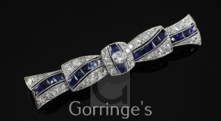 A 1930's/1940's Art Deco white gold, sapphire and diamond brooch, of stylised ribbon design and