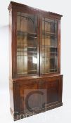A Regency mahogany bookcase, with moulded cornice, two astragal glazed doors over two ebony strung
