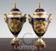 A pair of Coalport fruit painted pedestal vases and covers, post war, one signed D.Millar, both