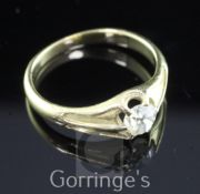 A gold and claw set solitaire diamond ring, with carved shoulders and old mine cut stone weighing