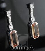 A pair of white gold, pale orange topaz and diamond drop earrings, set with elongated emerald cut