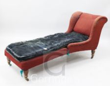 A late Victorian Howard & Sons day bed, with distressed upholstery and ring turned legs, on brass