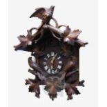 A Black Forest carved wood cuckoo clock, with two singing birds and bird and foliage carved case,