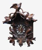 A Black Forest carved wood cuckoo clock, with two singing birds and bird and foliage carved case,