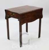 A George III mahogany butterfly Pembroke table, the serpentine rectangular top with carved border,