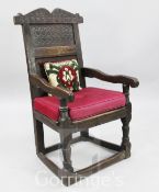 A 17th century and later oak wainscott chair, with roundel carved back and solid seat, H.3ft 5in.