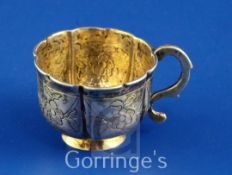 An early 19th century Russian 84 zolotnik silver gilt vodka cup, of shaped circular form, engraved