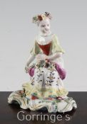 A Derby Pale Family figure of a seated lady, c.1756-9, holding flowers in her lap, a garland of