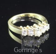 An 18ct gold and graduated five stone princess cut diamond half hoop ring, size P.