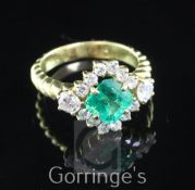 An 18ct gold, emerald and diamond cluster ring, of horizontal diamond shape, with central 1.48ct