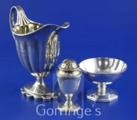 A George III silver helmet shaped cream jug, with engraved armorial and initials, fluted body and