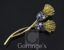 An 18ct gold, sapphire and diamond flower brooch, modelled as two overlapping stylised flowers and