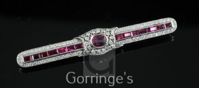 A mid 20th century white gold, ruby and diamond encrusted bar brooch, set with oval and baguette cut