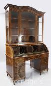 A late Victorian marquetry inlaid rosewood cylinder bureau bookcase, with arched cornice and three