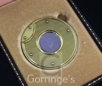 A cased Dunhill gold mounted stainless steel cigar cutter, of circular form, the front and back with