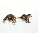 A PAIR OF SATURNO SILVER AND ENAMEL OTTERS, the larger approximately 6cm long