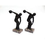 TWO BRONZED FIGURES OF DISCUS THROWERS, on rectangular marble plinth bases, after the original by