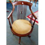 AN EDWARDIAN MAHOGANY REVOLVING ARMCHAIR with inlaid decoration on four splayed legs with brass