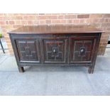 A CARVED OAK COFFER the panelled front with initials M.L.,152cm wide, 53cm deep, 68cm high