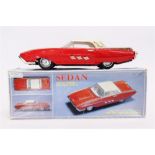 A CHINESE TINPLATE FORD THUNDERBIRD SEDAN red with a cream roof, fitted with a friction drive motor,