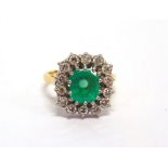 AN EMERALD AND DIAMOND CLUSTER RING stamped '18ct', the rectangular step cut stone, approximately